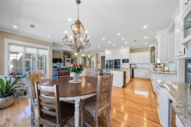 dining space with light wood-style floors, recessed lighting, visible vents, and crown molding