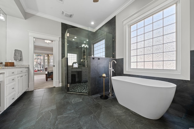 full bathroom featuring visible vents, tile walls, a freestanding bath, ornamental molding, and a stall shower