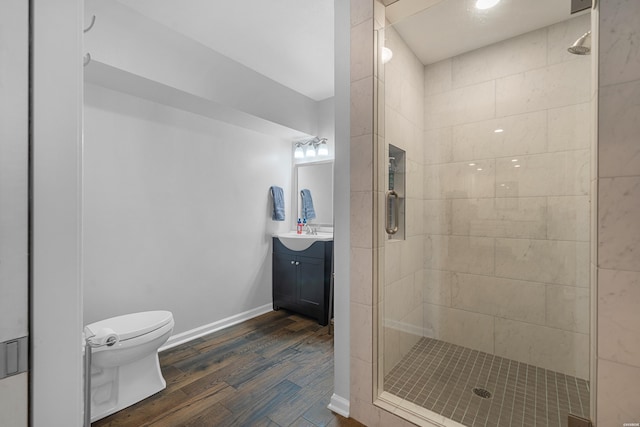 full bathroom with toilet, a stall shower, wood finished floors, and vanity