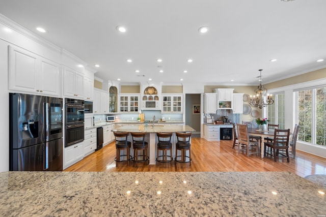 kitchen featuring dobule oven black, white cabinets, stainless steel refrigerator with ice dispenser, backsplash, and crown molding