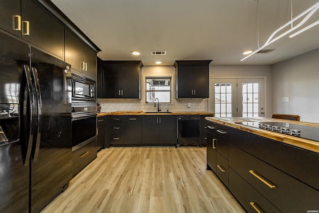 kitchen featuring visible vents, black appliances, wood counters, and a sink