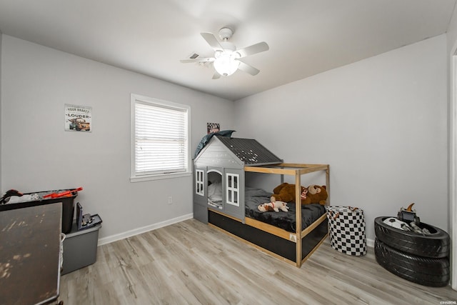 bedroom with a ceiling fan, baseboards, and wood finished floors