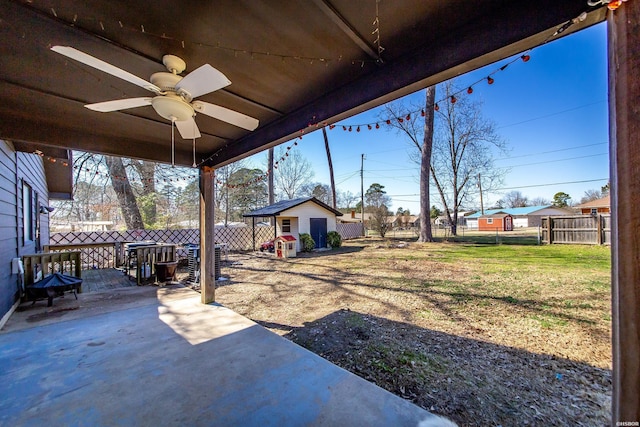 view of yard featuring a fenced backyard, ceiling fan, a patio, and an outdoor structure