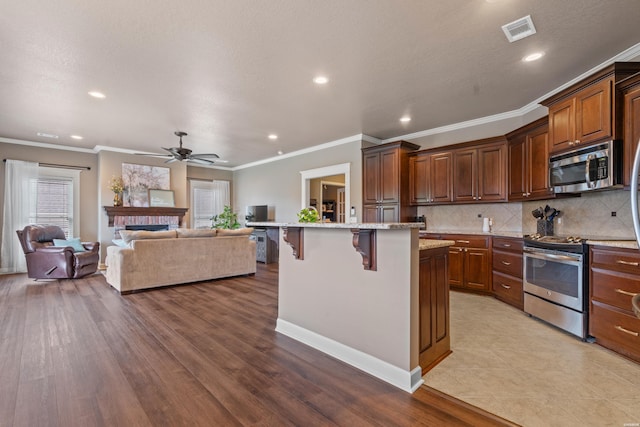 115 Gatehills Pl, Hot Springs, AR 71913 - kitchen with appliances with stainless steel finishes, a breakfast bar area, open floor plan, ceiling fan, and recessed lighting
