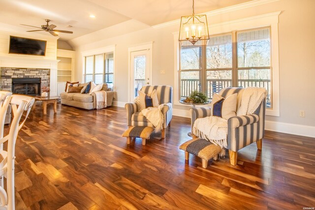 sitting room with baseboards, lofted ceiling, dark wood-style floors, a fireplace, and ceiling fan with notable chandelier