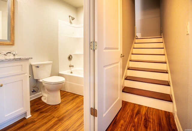 bathroom featuring shower / washtub combination, vanity, toilet, and wood finished floors