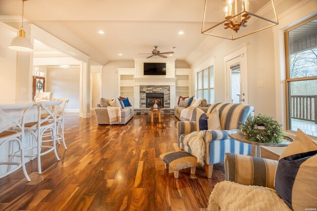 living area with built in shelves, recessed lighting, ceiling fan, a stone fireplace, and wood finished floors