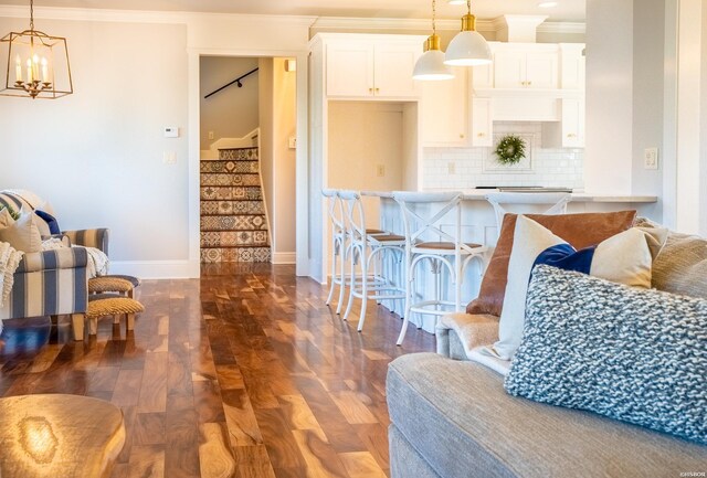 interior space with a chandelier, baseboards, stairway, dark wood-style floors, and crown molding