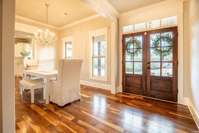 interior space featuring dark wood-style floors, french doors, crown molding, an inviting chandelier, and baseboards