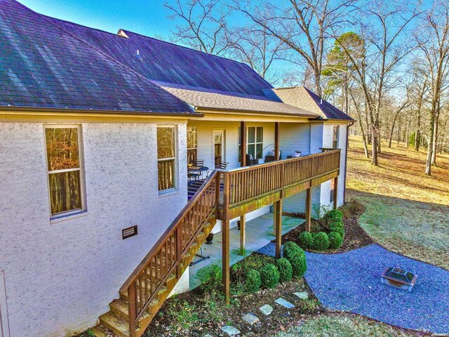 exterior space featuring crawl space and a shingled roof