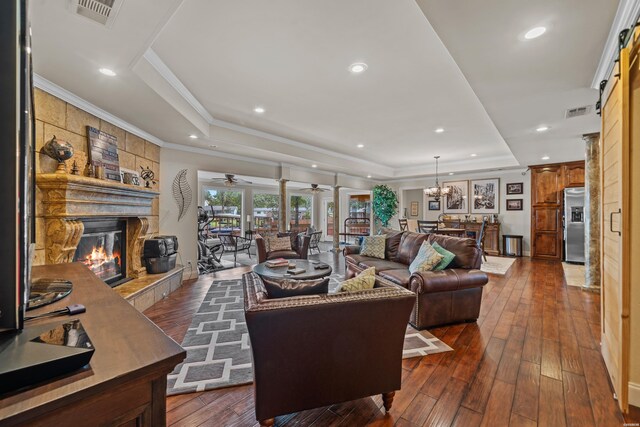 213 Gregory Dr, Hot Springs, AR 71913 - living room featuring dark wood finished floors, a raised ceiling, visible vents, a tiled fireplace, and a ceiling fan