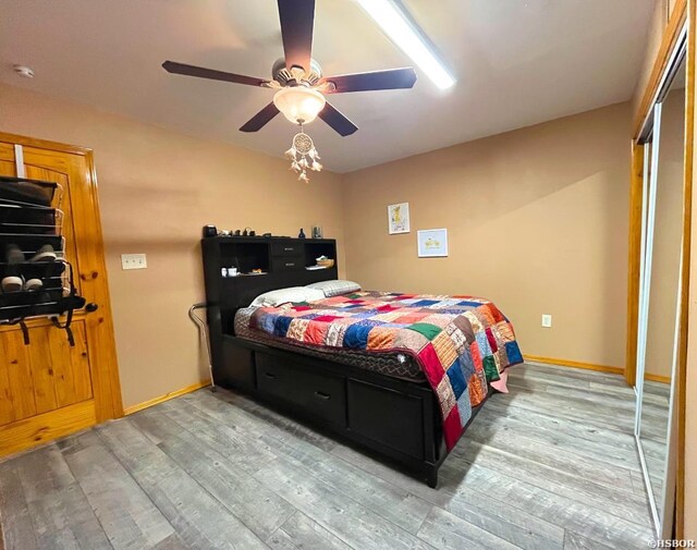 bedroom featuring ceiling fan, baseboards, and wood finished floors