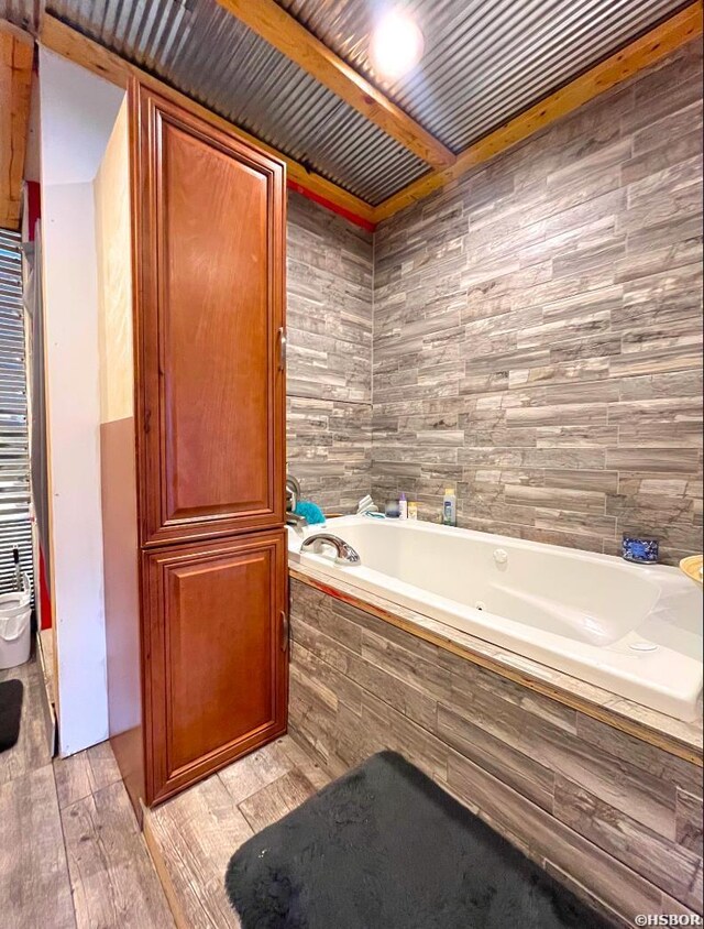 full bathroom with wood finished floors and a garden tub