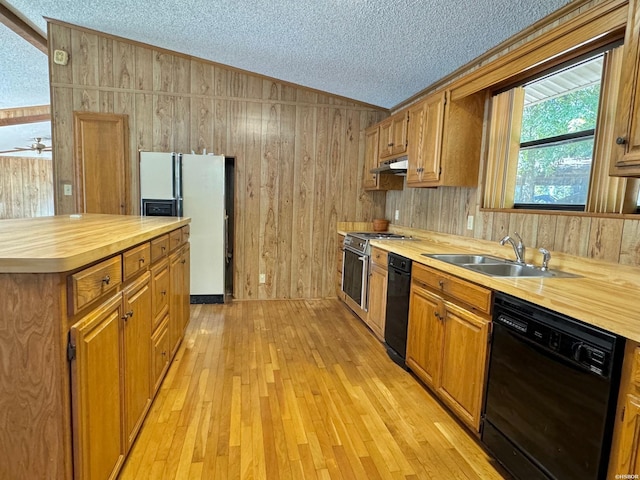 kitchen with white refrigerator with ice dispenser, light wood finished floors, brown cabinetry, a sink, and dishwasher