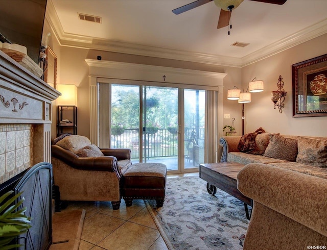 living room with visible vents, crown molding, a tiled fireplace, and light tile patterned floors