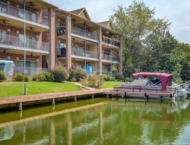 view of dock featuring a lawn and a water view