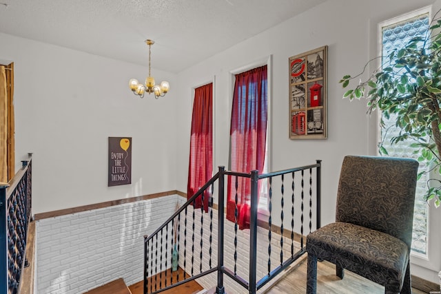108 Helen St, Hot Springs, AR 71913 - living area featuring plenty of natural light, a textured ceiling, a notable chandelier, and an upstairs landing
