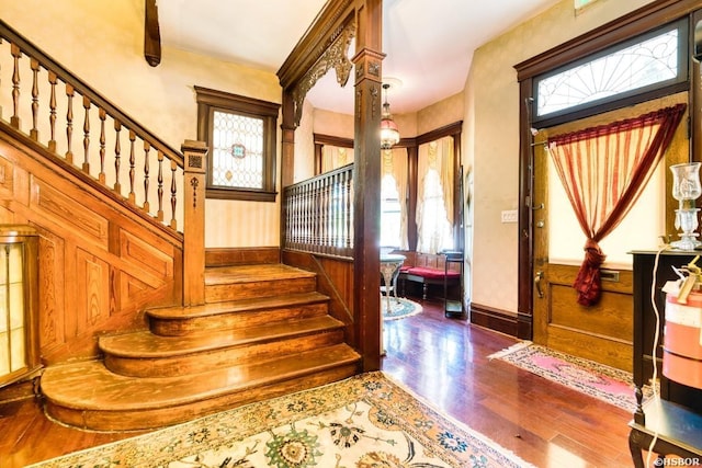 entryway with dark wood finished floors, stairway, and baseboards