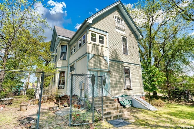 rear view of house with entry steps and fence