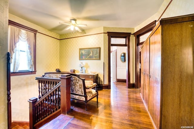 interior space with a barn door, wood finished floors, and wallpapered walls