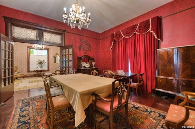 dining room featuring wallpapered walls, dark wood-style flooring, and an inviting chandelier