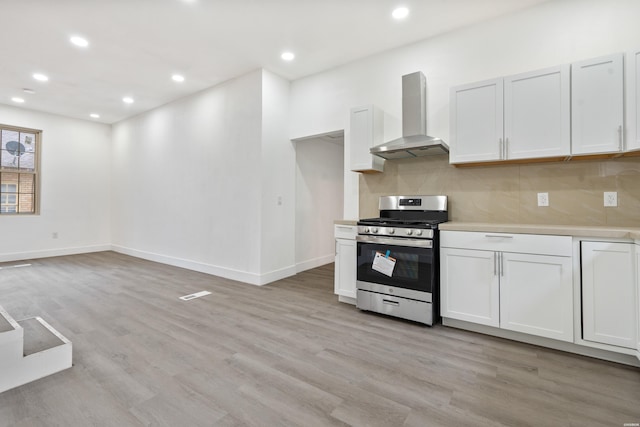 207 Hagen St, Hot Springs, AR 71913 - kitchen with wall chimney range hood, tasteful backsplash, light wood-style floors, light countertops, and stainless steel gas stove