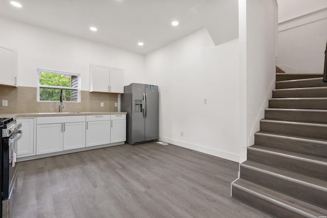 207 Hagen St, Hot Springs, AR 71913 - kitchen featuring light wood finished floors, a sink, light countertops, white cabinets, and appliances with stainless steel finishes