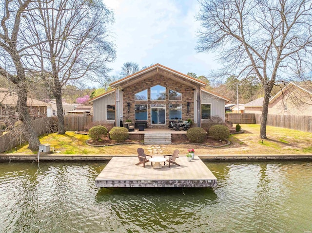 rear view of property featuring a water view, fence, and a patio
