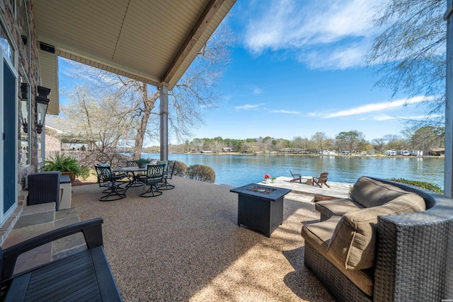 view of patio / terrace featuring an outdoor fire pit, outdoor dining area, and a water view