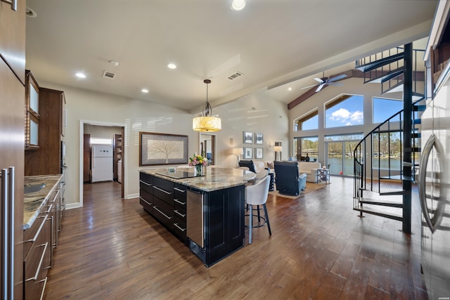 kitchen with a kitchen island, visible vents, dark wood-style flooring, and freestanding refrigerator