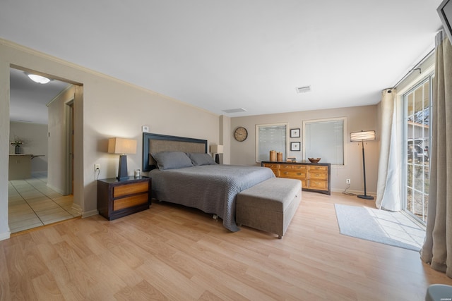 bedroom with ornamental molding, baseboards, light wood-style floors, and visible vents