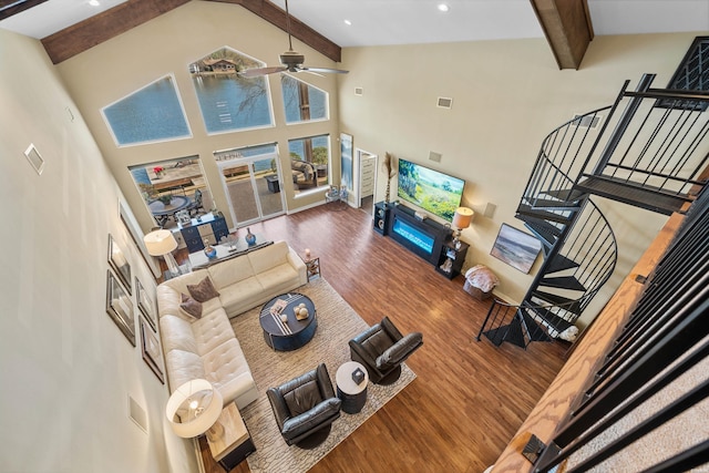 living area with stairs, high vaulted ceiling, beam ceiling, visible vents, and wood finished floors