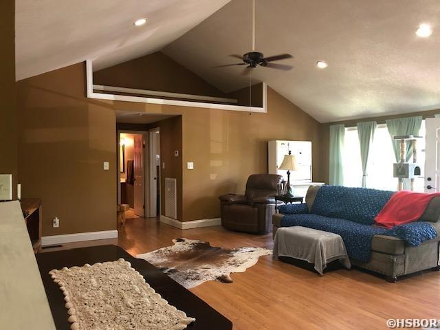 living area with recessed lighting, wood finished floors, high vaulted ceiling, and ceiling fan