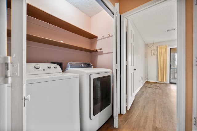 724 Weston Rd Unit Q-4, Hot Springs, AR 71913 - laundry area with washer and clothes dryer, a textured ceiling, and light wood-style flooring