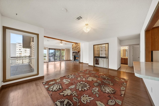 724 Weston Rd Unit Q-4, Hot Springs, AR 71913 - unfurnished living room with a stone fireplace, wood finished floors, a chandelier, and a ceiling fan