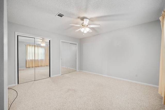 724 Weston Rd Unit Q-4, Hot Springs, AR 71913 - unfurnished bedroom featuring two closets, carpet flooring, a textured ceiling, and a ceiling fan