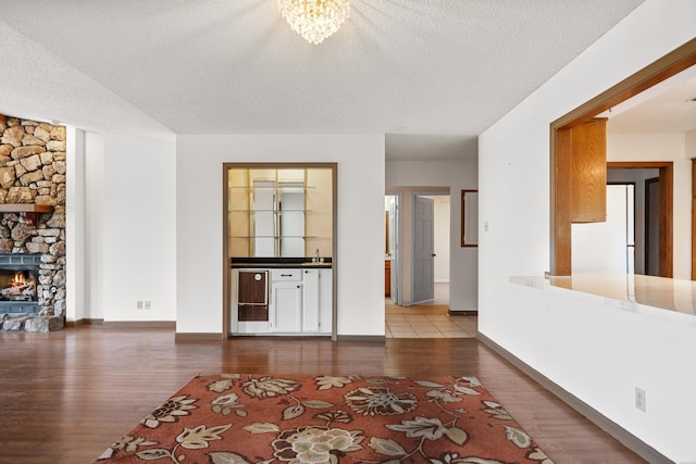 724 Weston Rd Unit Q-4, Hot Springs, AR 71913 - unfurnished living room with wood finished floors, a fireplace, a textured ceiling, and a chandelier