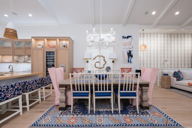 dining area with light wood finished floors, recessed lighting, an inviting chandelier, and beam ceiling