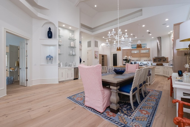 dining space featuring recessed lighting, a high ceiling, a notable chandelier, and light wood-type flooring