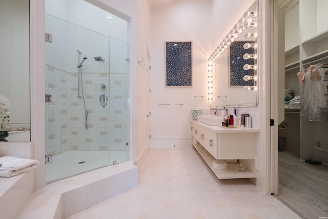 full bath with a spacious closet, vanity, and a stall shower