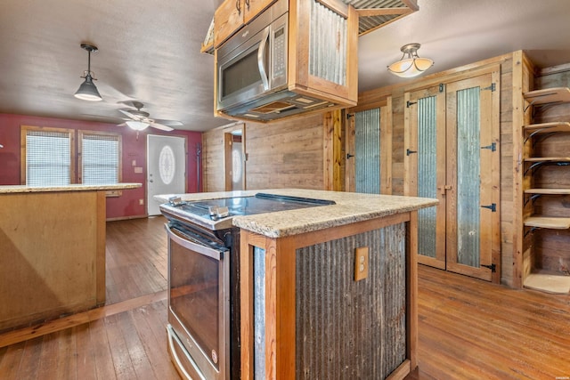 kitchen with pendant lighting, light countertops, appliances with stainless steel finishes, and a center island