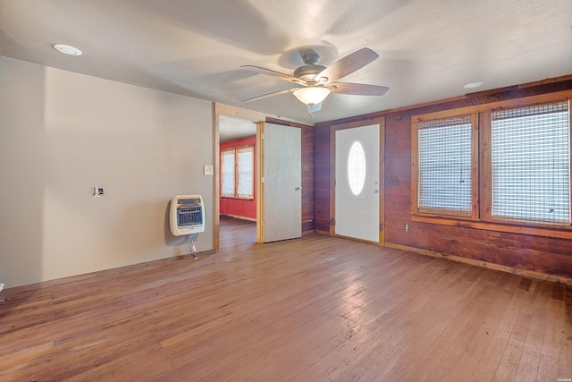 foyer entrance featuring baseboards, ceiling fan, heating unit, and wood finished floors