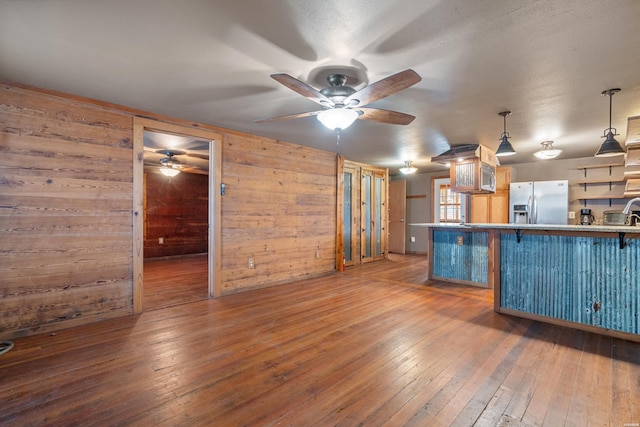 kitchen featuring dark wood-style floors, a breakfast bar, pendant lighting, and stainless steel refrigerator with ice dispenser