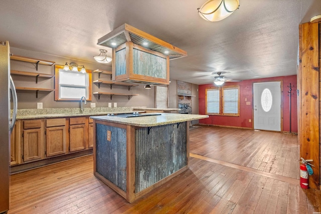 kitchen with a breakfast bar, light wood finished floors, open shelves, light countertops, and a kitchen island