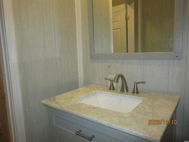 bathroom with wooden walls and vanity