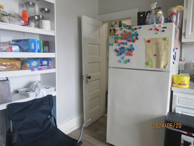 kitchen with wood finished floors and freestanding refrigerator