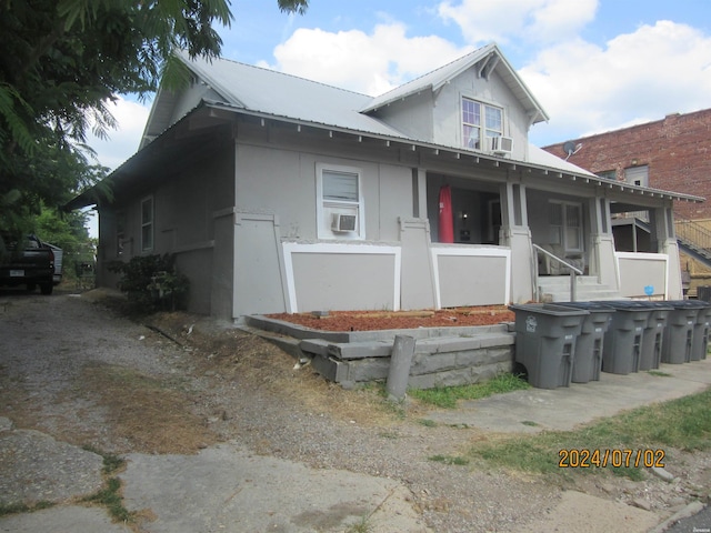 view of front of house with metal roof, cooling unit, and stucco siding