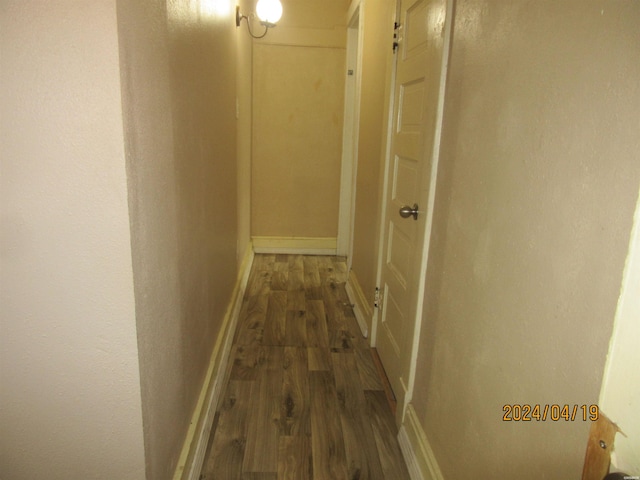 hall with baseboards and dark wood-style flooring