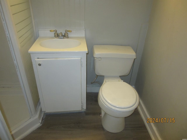 bathroom with toilet, wood finished floors, and vanity