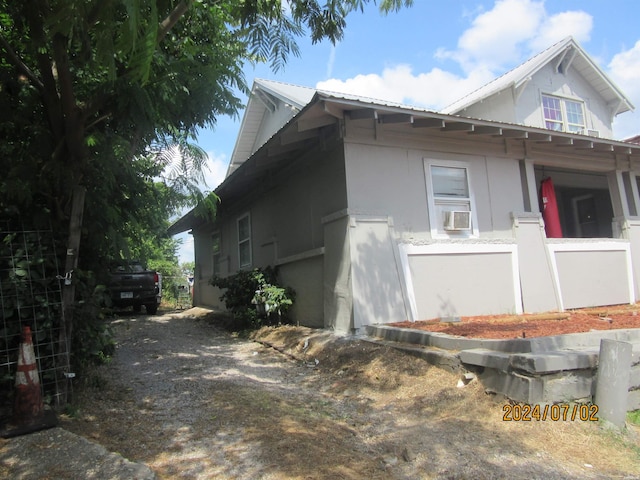 view of side of property with metal roof and stucco siding